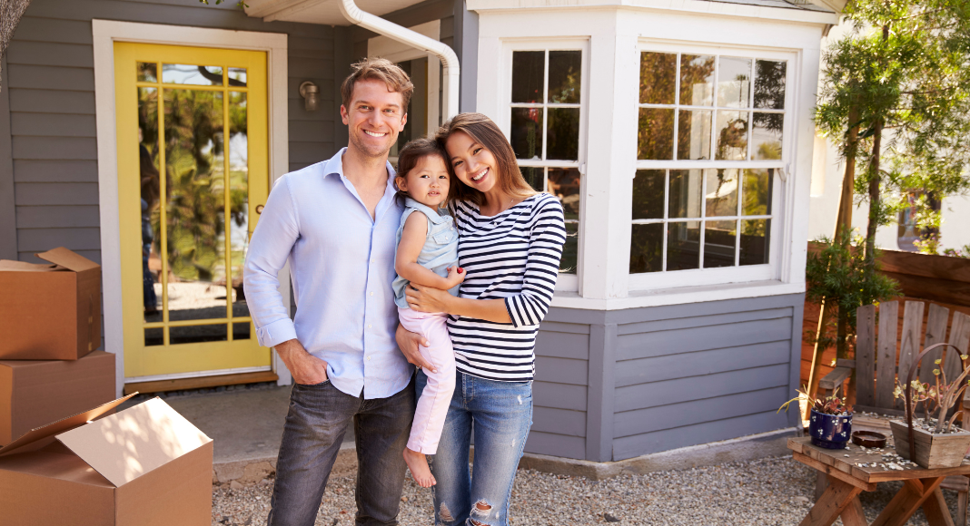 A family standing outside of their new home.