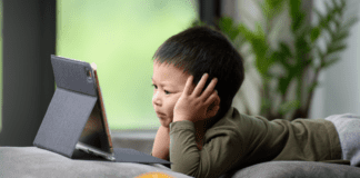 Beyond the Screen: The Neuropsychology of Digital Device Impact on Developing Brains A kid glued to his tablet with too much screen time.