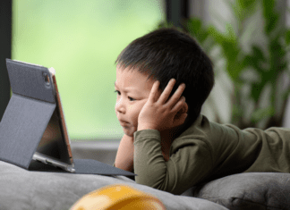 Beyond the Screen: The Neuropsychology of Digital Device Impact on Developing Brains A kid glued to his tablet with too much screen time.