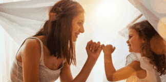 A mom making a pinky promise with her daughter.