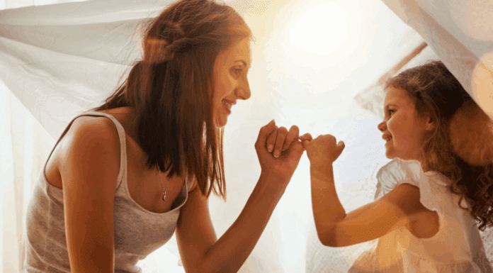 A mom making a pinky promise with her daughter.