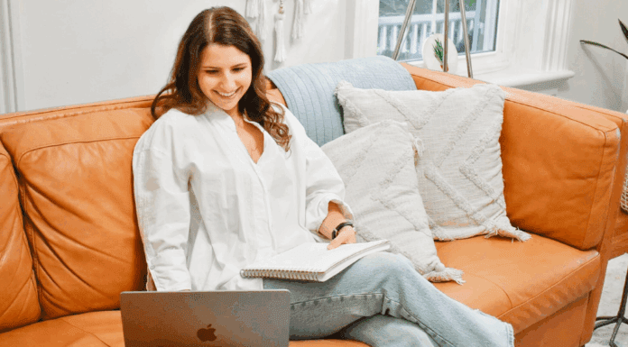 Brooke sitting on her couch on the computer.