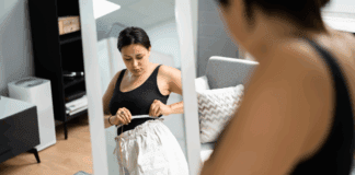 A woman measuring her weight loss.