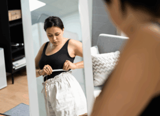 Pros and Cons of GLP-1 Medications A woman measuring her weight loss.
