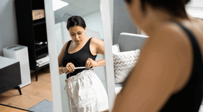 A woman measuring her weight loss.