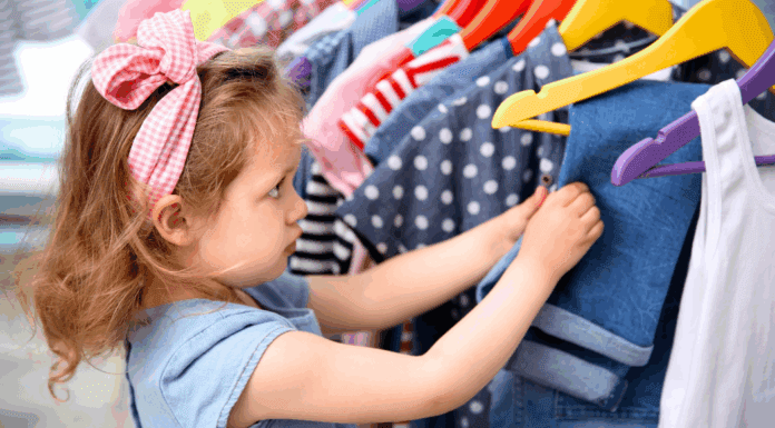 15 Tips to Save Money on Fall Fashions for Back-to-School A girl looking through a rack of clothes.