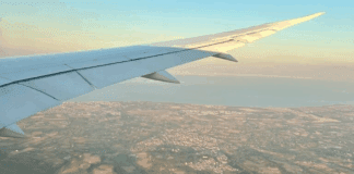 An airplane wing over land.