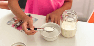 Adding sugar to a mason jar to make your own ice cream.