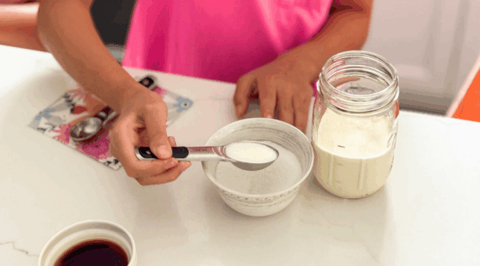 Adding sugar to a mason jar to make your own ice cream.