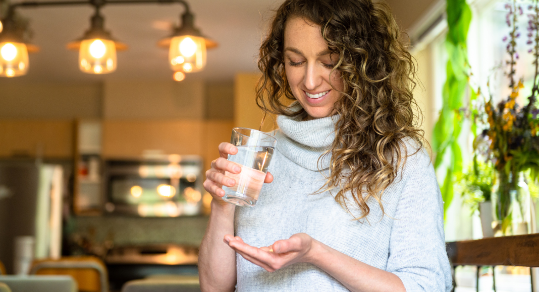 A woman taking a magnesium pill.