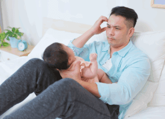 Is Dad All Right? A father struggling holding a baby.