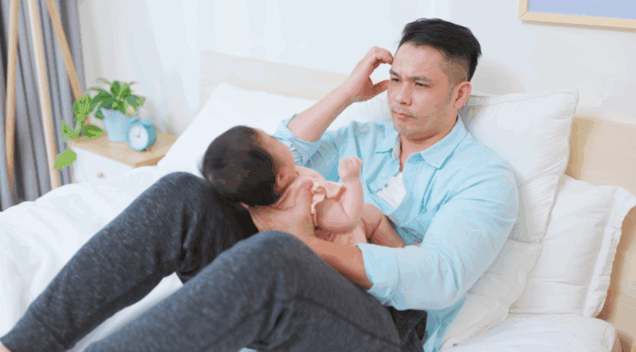 A father struggling holding a baby.