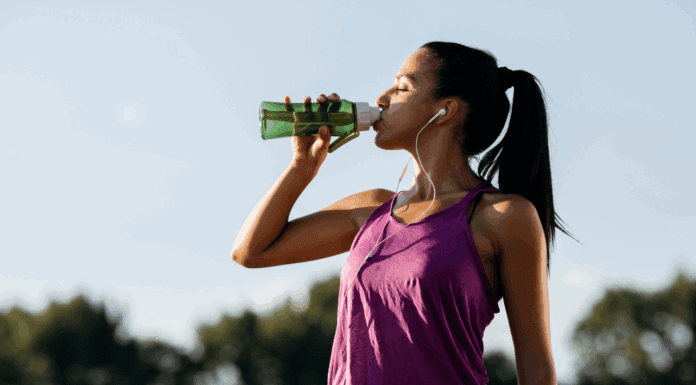 A woman drinking water after a workout.
