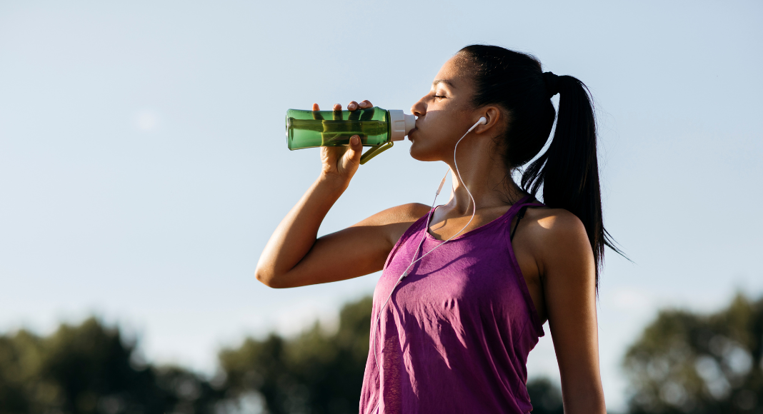 A woman drinking water after a workout.