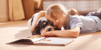 National Book Lovers Day A girl reading a book to her dog.