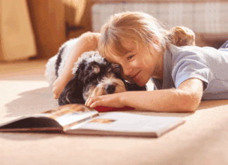 A girl reading a book to her dog.