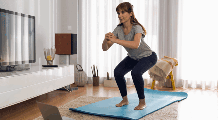 A woman working out on a yoga mat at home.