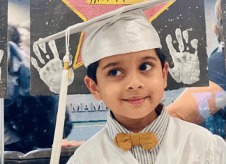 A little boy in his preschool graduation cap and gown.