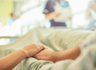 Life is Precious People holding hands in a hospital bed.