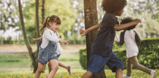Overcoming Social Challenges Kids chasing each other outside around a tree.