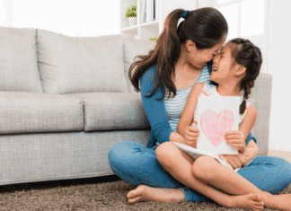 A mom holding her daughter in her lap.