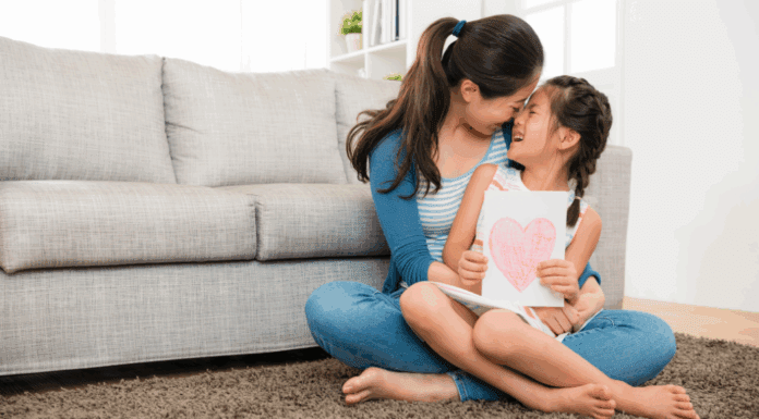 I’m That Mom A mom holding her daughter in her lap.