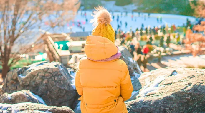 Thanksgiving Weekend in NYC: A 3-Day Game Plan for Families Child in orange coat and hat overlooking the ice rink during Thanksgiving Weekend in NYC