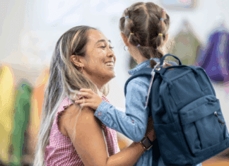 A mom saying goodbye to her daughter at school drop-off.