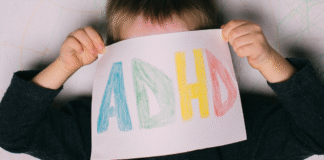 The Other Side of ADHD A child holding a sign that says "ADHD."