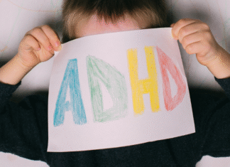 The Other Side of ADHD A child holding a sign that says "ADHD."