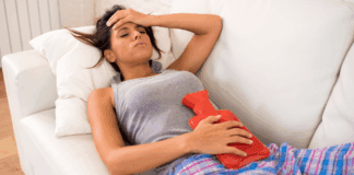 It’s Time to Talk About Being a Woman A woman on her peirod holding a hot pad to ease cramps.