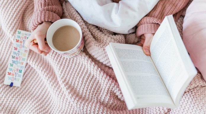 Holding a book and coffee.