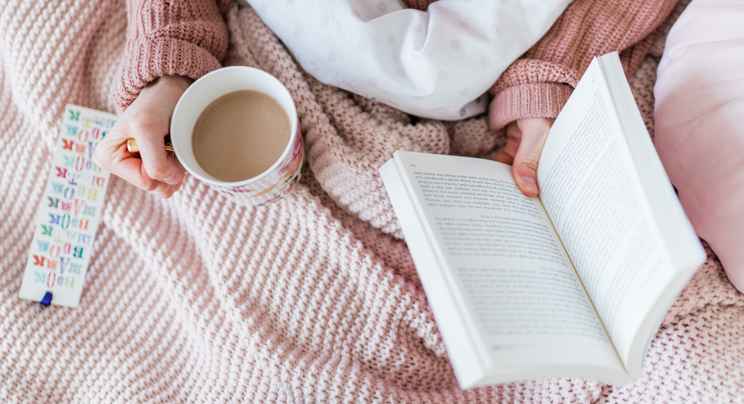 Holding a book and coffee.