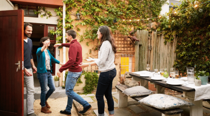 A couple greeting dinner guests.