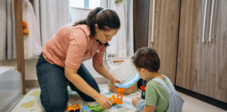 A mom playing on the floor with her son.