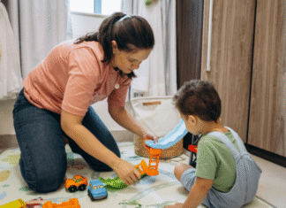 A mom playing on the floor with her son.