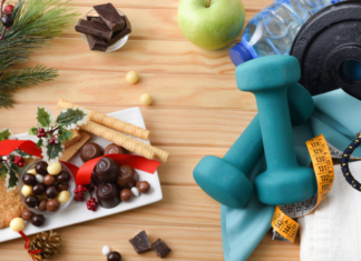 Why Throwing in the Towel Until January Doesn’t Work — And What To Do Instead A plate of holiday food next to workout equipment.