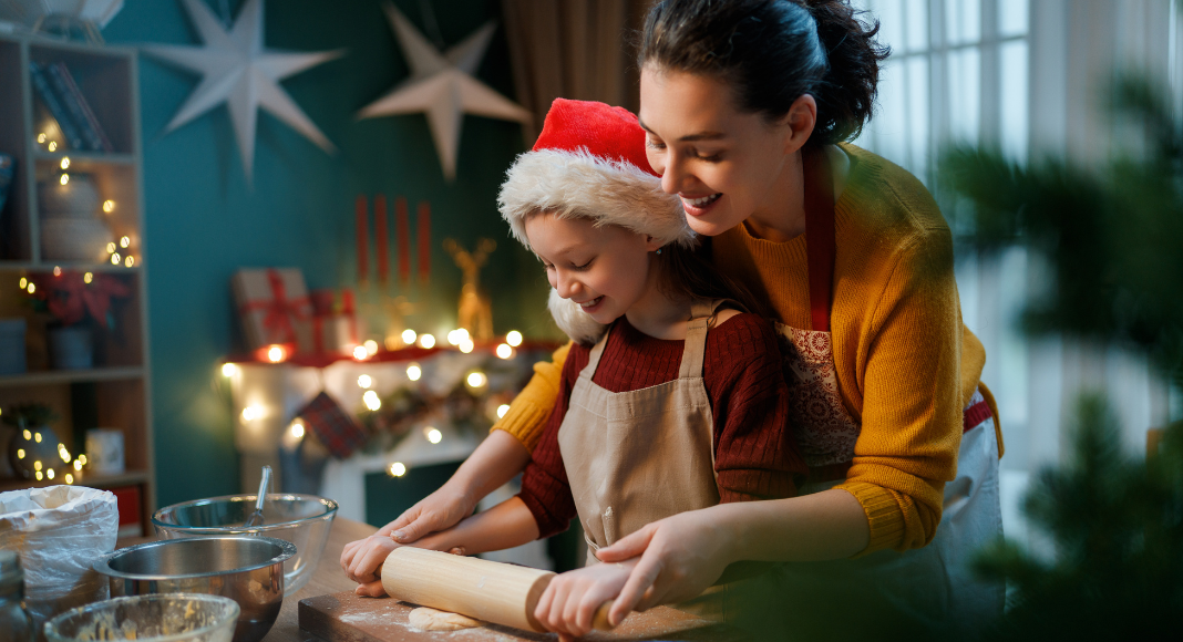 A mom and daughter rolling out Cookie dough during Christmas. 