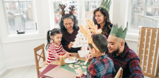 A family wearing hats and making a craft.