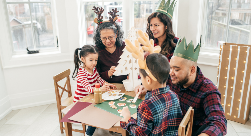 A family wearing hats and making a craft.