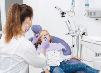 Building Healthy Smiles in Westchester County: Why “Timely” Orthodontic Care Matters Summerfield Orthodontics doctor examining a patient.