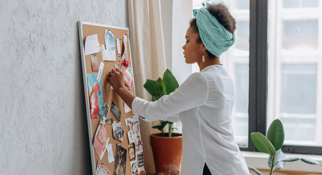 A woman creating her dreams on a vision board.