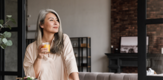 A woman drinking a glass of orange juice.