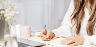 A woman sitting down to write a book.