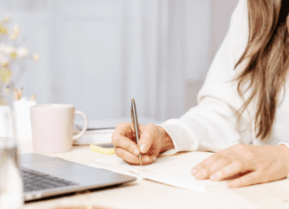 A woman sitting down to write a book.