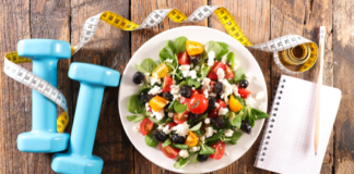 A Guide to Fitness, Health, & Wellness in Westchester County A healthy salad next to 5lb weights and a notebook.