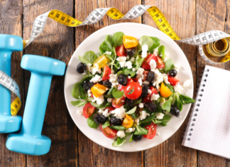 A Guide to Fitness, Health, & Wellness in Westchester County A healthy salad next to 5lb weights and a notebook.