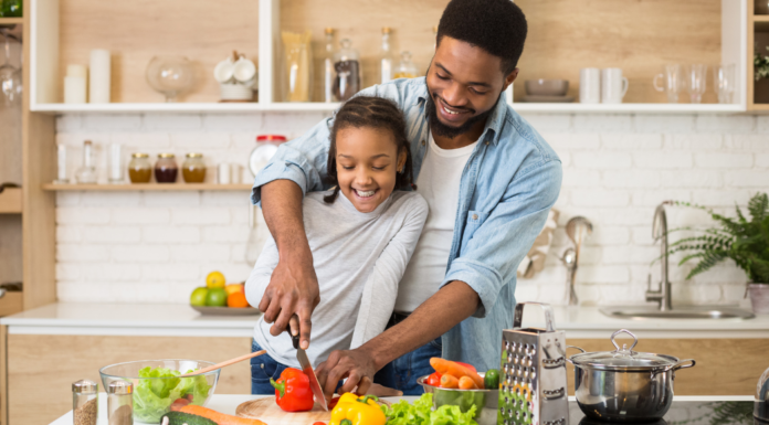 Healthy Family Habits to Start This Year A dad and daughter chopping vegetables in the kitchen.