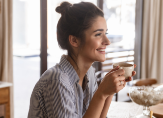 A woman pausing and enjoying a cup of coffee.