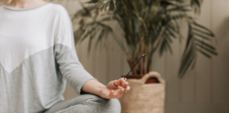 New Year, Same Me A woman meditating holding incense.